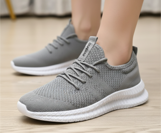 Grey knitted trainers with white soles on wooden floor, designed for comfort and style, ideal for casual outings
