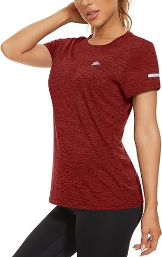 Woman wearing red athletic t-shirt and black leggings, posing with hand on hip, showcasing casual workout outfit
