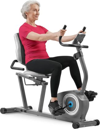 Elderly woman exercising on recumbent bike wearing red top and black leggings, promoting fitness and healthy lifestyle