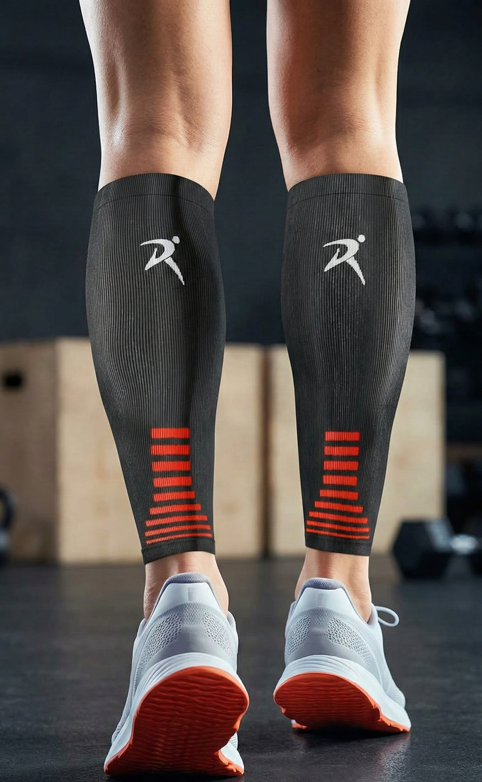 Close-up of person wearing black compression sleeves with red accents and grey trainers in a gym setting